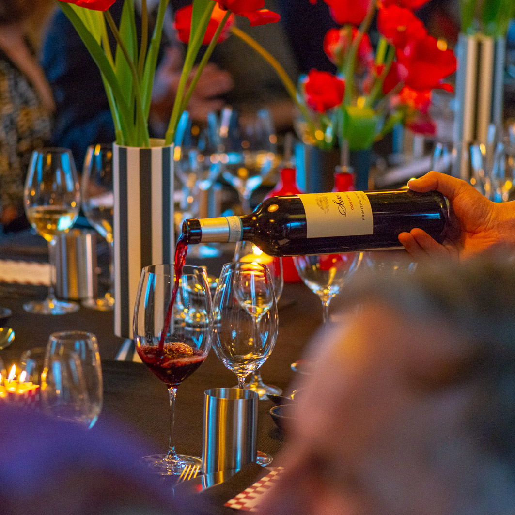 Staff serving bottle of wine at the dinner table